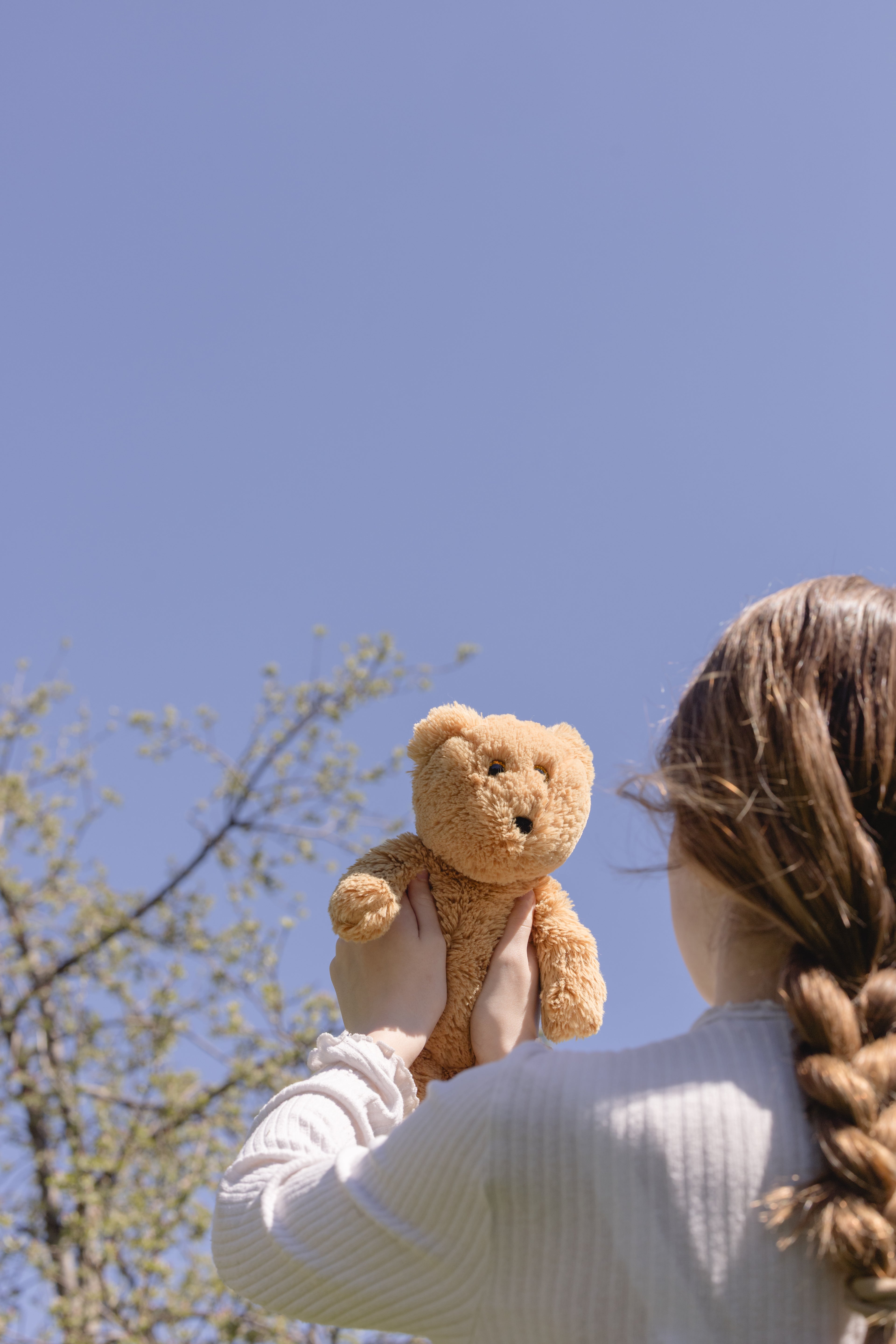 Child holding her stuffed animal, second-hand toys, cleaned and repaired